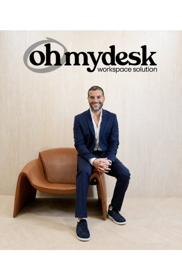Guillaume Rassemi seated in a leather armchair in front of the Oh My Desk logo